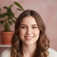 Close-up portrait of a smiling young woman with light brown hair, conveying trust and happiness.